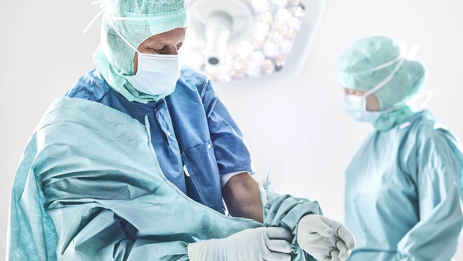 Kirurg, der er ved at tage sin kittel på inden operationen