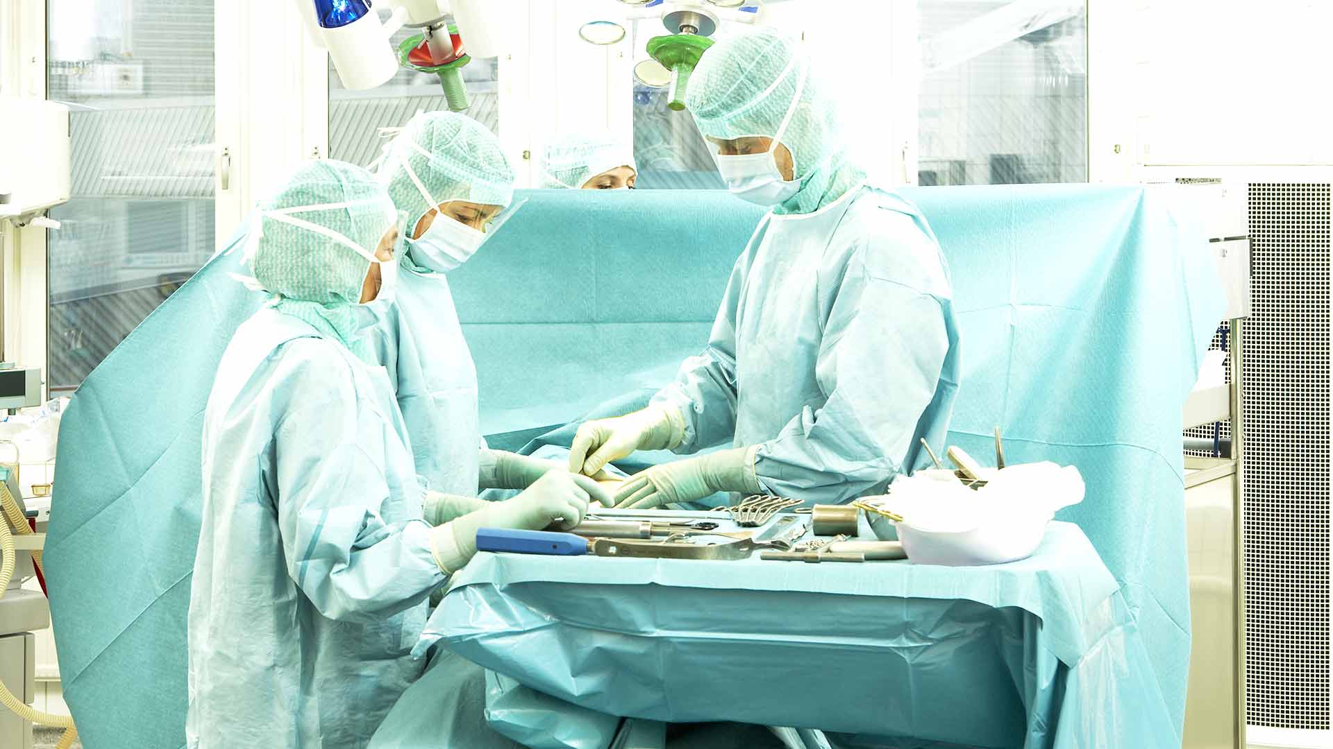 læger på operationsstue gør kirurgiske instrumenter klar