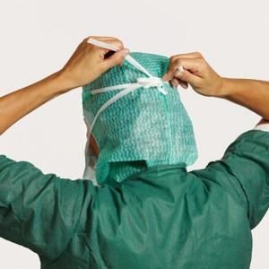 Sundhedsmedarbejder binder maske bag på hovedet